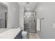 Modern bathroom featuring a tiled walk-in shower with glass door and vanity with marbled countertop at 184 Mort Harris Rd, Louisburg, NC 27549