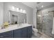 Elegant bathroom featuring a blue vanity, a spacious shower with decorative tile, and modern fixtures at 184 Mort Harris Rd, Louisburg, NC 27549