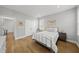 A bright bedroom with warm hardwood floors, two windows, white bedding, and stylish decor at 184 Mort Harris Rd, Louisburg, NC 27549