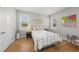 A cozy bedroom with warm hardwood floors, two windows, white bedding, and stylish decor at 184 Mort Harris Rd, Louisburg, NC 27549
