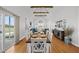Open-concept dining area with a view into the living room, hardwood floors, and rustic wooden table at 184 Mort Harris Rd, Louisburg, NC 27549