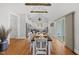 Open-concept dining area with hardwood floors, wooden table set for dinner, and view into the kitchen at 184 Mort Harris Rd, Louisburg, NC 27549