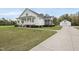 Charming two-story white farmhouse-style home with a welcoming front porch and manicured landscaping at 184 Mort Harris Rd, Louisburg, NC 27549