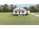 Inviting two-story home with a classic white exterior, complemented by a lush green lawn and front porch at 184 Mort Harris Rd, Louisburg, NC 27549