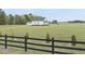 Charming white farmhouse with black trim on a sprawling green lawn, framed by a black fence at 184 Mort Harris Rd, Louisburg, NC 27549