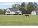 Beautiful home and a buffalo statue, on an expansive manicured lawn at 184 Mort Harris Rd, Louisburg, NC 27549