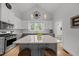 Bright kitchen with white upper cabinets, gray lower cabinets, a large island, and modern pendant lighting at 184 Mort Harris Rd, Louisburg, NC 27549