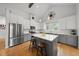 Bright open kitchen with stainless appliances, white cabinets, gray island, and stylish compass decoration at 184 Mort Harris Rd, Louisburg, NC 27549