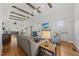Cozy living room featuring wooden beam ceiling, a fireplace, modern decor, and an open view to the kitchen at 184 Mort Harris Rd, Louisburg, NC 27549