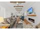 Cozy living room with a modern fireplace, hardwood floors, vaulted ceiling beams, and an open floor plan at 184 Mort Harris Rd, Louisburg, NC 27549