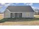 Rear exterior view displays well-maintained lawn, covered patio, and gray siding at 198 Ruskin Dr, Smithfield, NC 27577