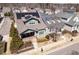 Aerial view of a two-story home with solar panels, a front porch, landscaped yard, and surrounding neighborhood at 1980 Great Ridge Pkwy, Chapel Hill, NC 27516