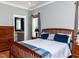 Bedroom features a wood bed frame with a view to the ensuite bath, wood floors, and neutral walls at 1980 Great Ridge Pkwy, Chapel Hill, NC 27516