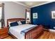 Comfortable bedroom features a wood bed frame, with blue accent wall, and wood floors at 1980 Great Ridge Pkwy, Chapel Hill, NC 27516