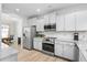 Modern kitchen featuring granite countertops, stainless steel appliances, and white cabinetry at 206 Drayton Hall Ln, Sanford, NC 27330