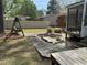Backyard with a charming swing set, a decorative dry pond, and a screened porch, perfect for outdoor enjoyment at 2102 Michael Ln, Smithfield, NC 27577