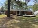 Brick home with a spacious backyard featuring a screened porch, deck, and a cozy swing for outdoor relaxation at 2102 Michael Ln, Smithfield, NC 27577