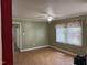 Open living area with a large window, ceiling fan, laminate floors, and neutral paint at 2102 Michael Ln, Smithfield, NC 27577