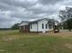 Back view of home showing brick and white siding and a small porch with wooden stairs at 2130 Pearidge Rd, Angier, NC 27501