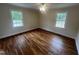 Bright bedroom featuring gleaming hardwood floors, neutral walls, and a classic ceiling fan at 2130 Pearidge Rd, Angier, NC 27501