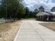 View of the concrete driveway leading to a brick home with a white picket fence at 2130 Pearidge Rd, Angier, NC 27501