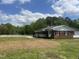Side view of brick home, showing the white fence and newly seeded yard at 2130 Pearidge Rd, Angier, NC 27501