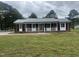 Charming brick home with a metal roof, covered porch, and freshly landscaped yard at 2130 Pearidge Rd, Angier, NC 27501