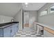 Finished attic featuring black and white checkered floors, gray cabinets, and natural lighting at 2200 Paddstowe Main Way, Wake Forest, NC 27587