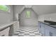 Finished attic featuring black and white checkered floors, gray cabinets, and natural lighting at 2200 Paddstowe Main Way, Wake Forest, NC 27587
