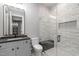 Modern bathroom features a glass enclosed shower, gray tile, and vanity at 2200 Paddstowe Main Way, Wake Forest, NC 27587