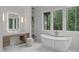 Luxurious bathroom featuring a soaking tub, wood vanity, and bright lighting at 2200 Paddstowe Main Way, Wake Forest, NC 27587