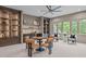 Comfortable bonus room features a custom bar, game table, large windows, and custom shelving at 2200 Paddstowe Main Way, Wake Forest, NC 27587