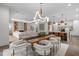 Open-concept dining area with stylish chandelier and seamless flow to living and kitchen spaces at 2200 Paddstowe Main Way, Wake Forest, NC 27587