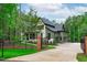 Stunning, luxury home with a gated entrance, stone accents, and lush landscaping at 2200 Paddstowe Main Way, Wake Forest, NC 27587