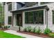 Elegant home entrance with stone facade, dark trim windows and manicured landscaping at 2200 Paddstowe Main Way, Wake Forest, NC 27587
