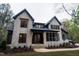 Stunning stone home with black trim, complemented by lush landscaping at 2200 Paddstowe Main Way, Wake Forest, NC 27587