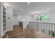 Bright hallway features hardwood floors, decorative lighting, and black metal railings overlooking the level below at 2200 Paddstowe Main Way, Wake Forest, NC 27587