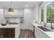A modern kitchen features white cabinets, stone countertops, and stainless-steel appliances at 2200 Paddstowe Main Way, Wake Forest, NC 27587
