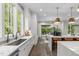 Well-lit kitchen with double islands, stone countertops, stainless steel sink and doors to outside patio at 2200 Paddstowe Main Way, Wake Forest, NC 27587
