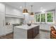 Modern kitchen featuring a large island, stone countertops, stainless steel appliances, and natural light at 2200 Paddstowe Main Way, Wake Forest, NC 27587