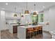 Spacious kitchen featuring double islands, stone countertops, pendant lighting, and stainless steel appliances at 2200 Paddstowe Main Way, Wake Forest, NC 27587