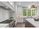 Kitchen with a stainless steel range, large island, white cabinetry, and bright natural light at 2200 Paddstowe Main Way, Wake Forest, NC 27587