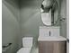 Stylish half-bathroom features a modern vanity, sleek fixtures, and an oval mirror over the sink at 2200 Paddstowe Main Way, Wake Forest, NC 27587