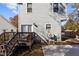 View of the home's back exterior featuring a wooden deck and gray siding under a sunny sky at 2207 Otis St # B, Durham, NC 27707