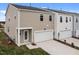Rear view of modern townhome featuring an attached garage, back door, and manicured lawn at 2313 Kasota Ln, Raleigh, NC 27610
