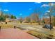 Backyard featuring a red tiled patio, long driveway, and basketball hoop at 2319 Somers Ave, Burlington, NC 27215