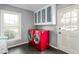 Functional laundry room featuring a red washer and dryer, storage cabinets, and a window at 2319 Somers Ave, Burlington, NC 27215