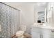 Cozy bathroom features a shower with patterned curtain and white single sink vanity at 241 N Nolan Park Dr, Selma, NC 27576