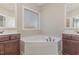 Bathroom featuring dual vanities, a corner soaking tub, and a large window for natural lighting at 2440 Us 70 A, Selma, NC 27576