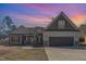 Charming two-story home featuring a two-car garage, landscaped yard and inviting front porch during sunset at 2440 Us 70 A, Selma, NC 27576